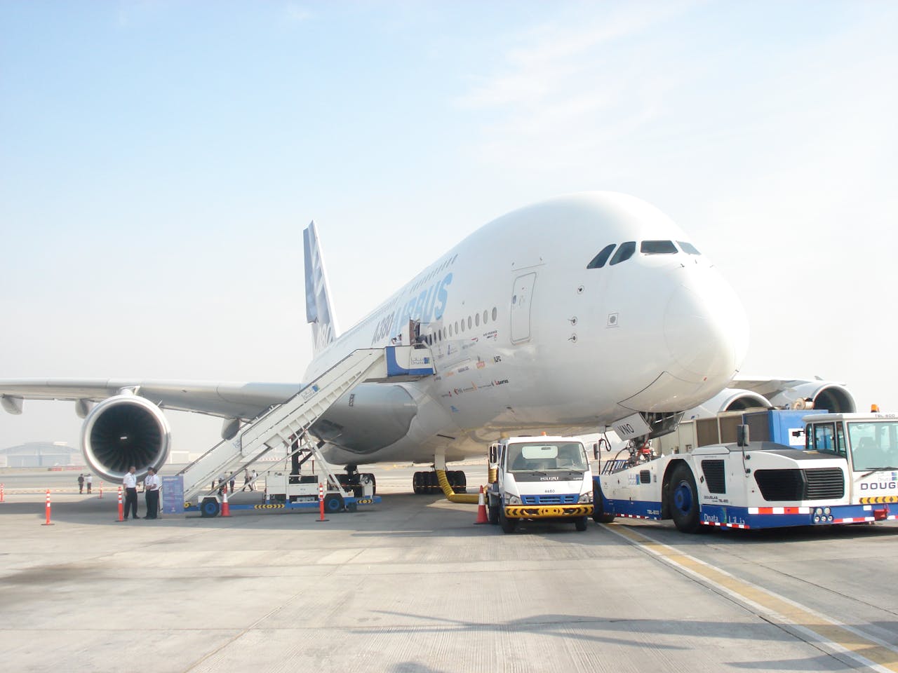 Huge commercial aircraft preparing for departure at airport with ground support vehicles.